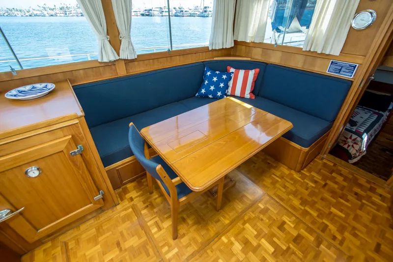 Slide: The Image of Interior of 1995 Grand Banks 42 Classic yacht with wooden table and blue seating. - 26