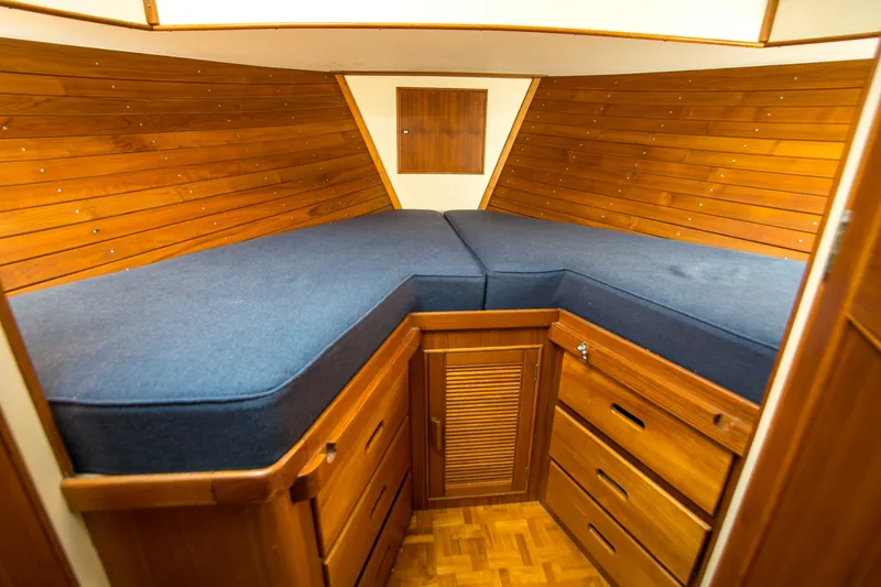 Slide: The Image of 1995 Grand Banks 42 Classic cabin interior with wooden paneling and blue cushions. - 32
