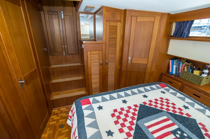 Slide: The Image of Cozy cabin interior of 1995 Grand Banks 42 Classic with wooden furnishings and quilted bedspread. - 34