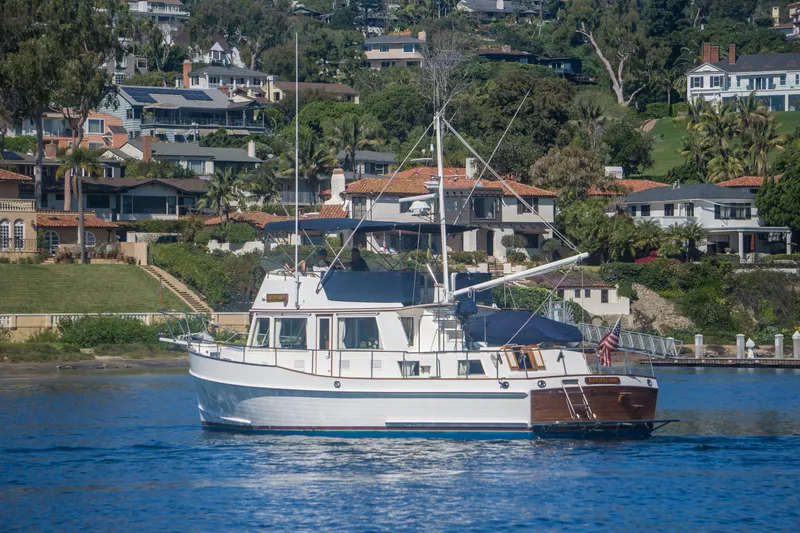 Slide: The Image of 1995 Grand Banks 42 Classic yacht cruising near waterfront homes. - 4