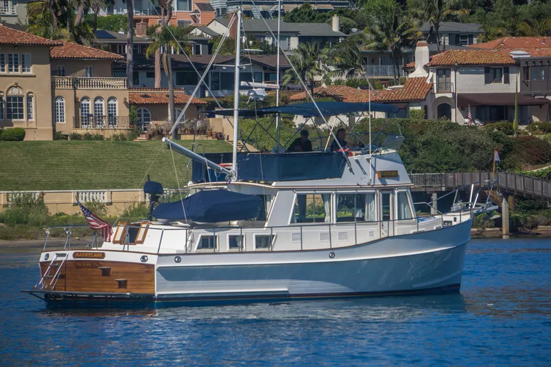 Slide: The Image of 1995 Grand Banks 42 Classic yacht cruising near waterfront homes. - 5