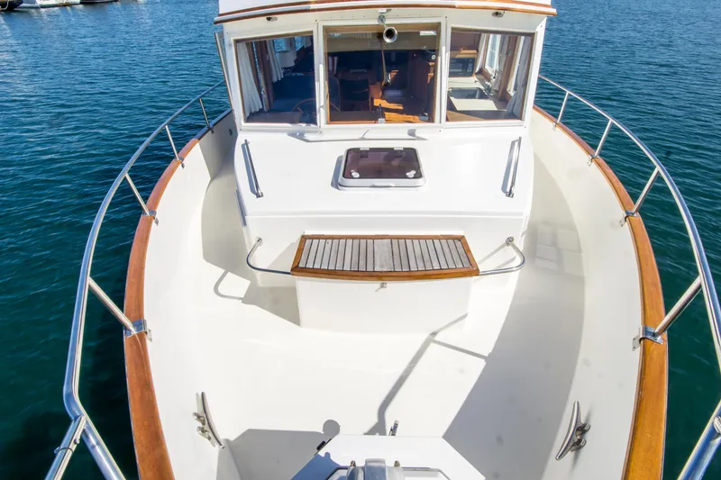 Slide: The Image of 1995 Grand Banks 42 Classic yacht bow, featuring teak accents and spacious deck. - 7