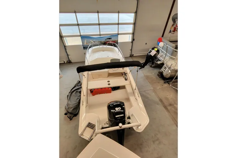 Slide: The Image of 2025 Boston Whaler 160 Super Sport boat in showroom, rear view with motor. - 5