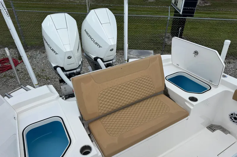 Slide: The Image of 2025 Caymas 291 boat with dual Mercury engines, tan seating, and storage compartments. - 11