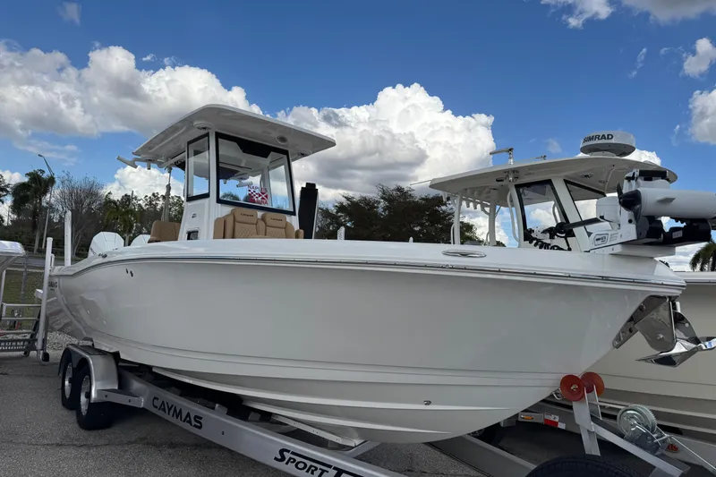 Slide: The Image of 2025 Caymas 291 boat on trailer under blue sky with clouds. - 2