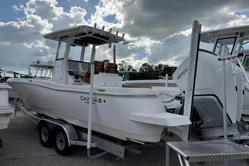 Slide: The Image of 2025 Caymas 291 boat on trailer, featuring Mercury engine, under cloudy sky. - 3