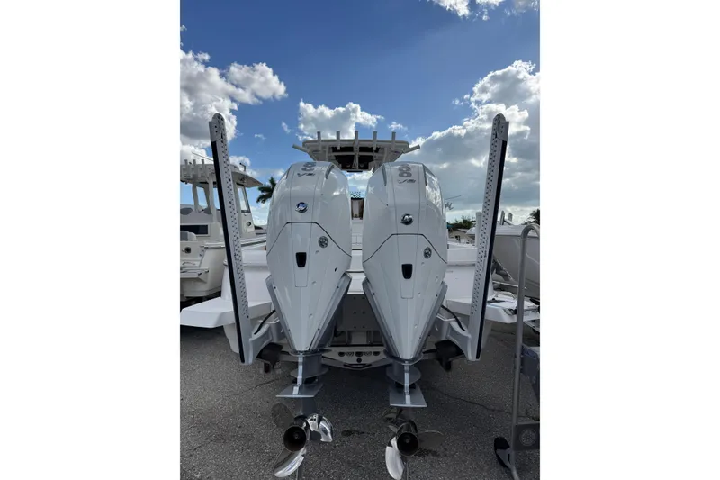 Slide: The Image of 2025 Caymas 291 boat with dual outboard engines under a partly cloudy sky. - 4