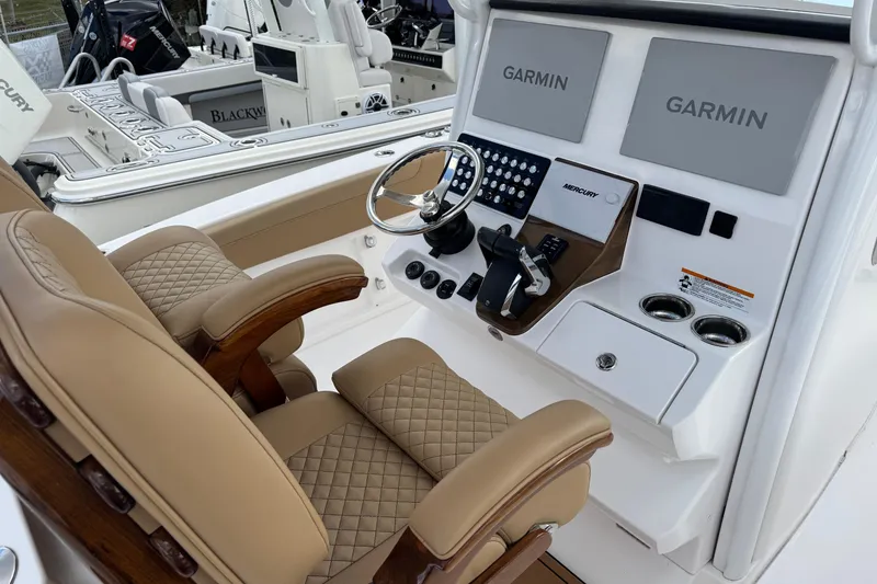Slide: The Image of 2025 Caymas 291 boat cockpit with Garmin displays and luxurious seating. - 6