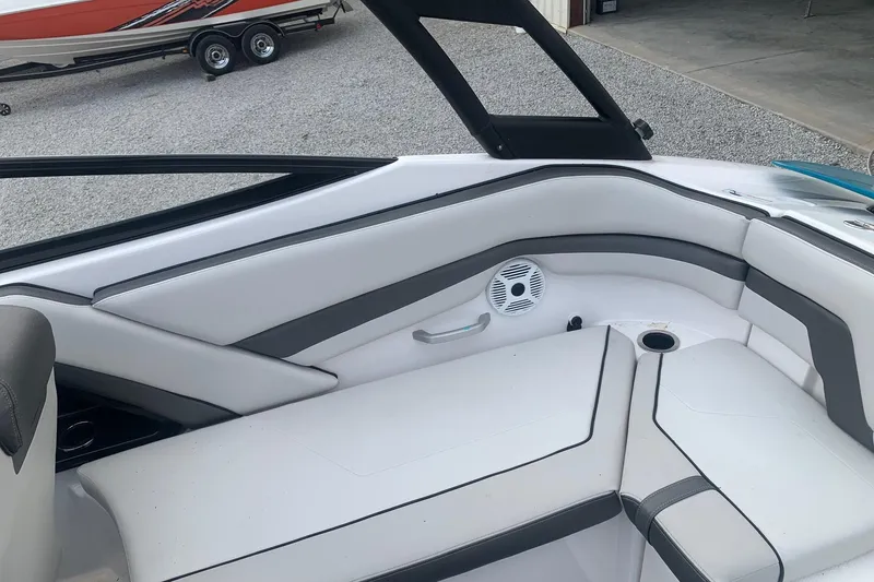 Slide: The Image of 2019 Yamaha AR240 boat interior with white and gray seating, speaker, and cup holder. - 11