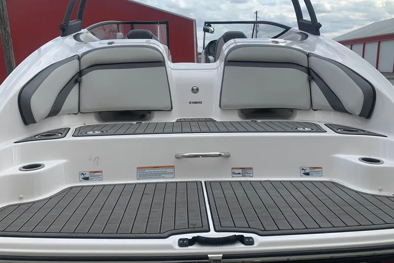 Slide: The Image of 2019 Yamaha Boats AR240 rear deck with cushioned seating and non-slip flooring. - 5