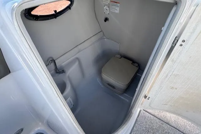 Slide: The Image of 2006 Crownline 270 BR boat interior with compact bathroom and portable toilet. - 21
