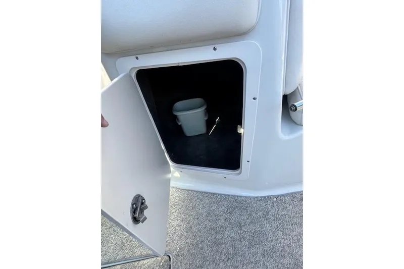 Slide: The Image of Open storage compartment on 2006 Crownline 270 BR boat with a small bucket inside. - 22
