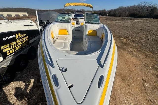 Slide: The Image of 2006 Crownline 270 BR boat with yellow accents, parked on a trailer outdoors. - 4