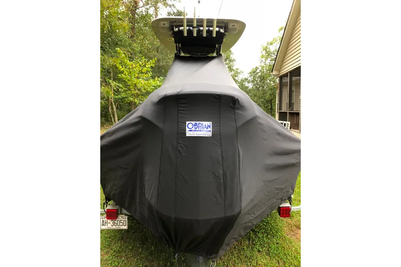 Slide: The Image of 2018 Key West 230 Bay Reef boat covered, parked outdoors near a house. - 11