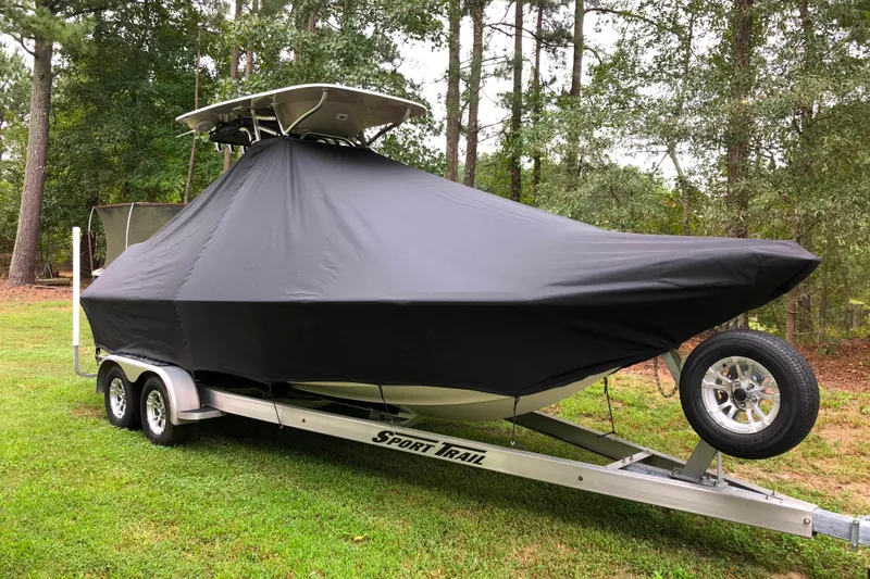 Slide: The Image of 2018 Key West 230 Bay Reef boat covered on trailer in wooded area. - 12