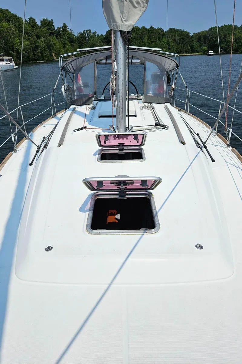 Slide: The Image of 2012 Beneteau Oceanis 37 sailboat deck with open hatches on a sunny day. - 14