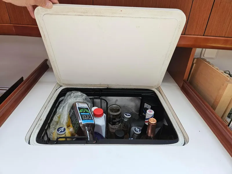 Slide: The Image of Storage compartment on a 2012 Beneteau Oceanis 37 yacht, containing various bottles and items. - 21