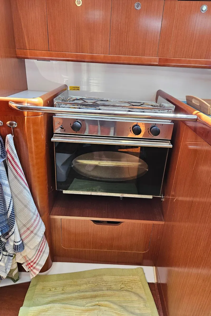 Slide: The Image of Galley kitchen in 2012 Beneteau Oceanis 37 sailboat with oven and wooden cabinetry. - 22