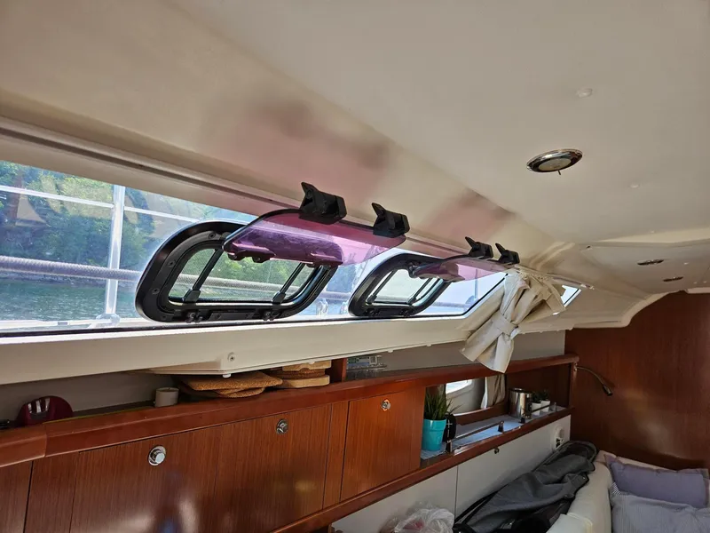 Slide: The Image of Interior of 2012 Beneteau Oceanis 37 yacht, featuring windows and wooden cabinetry. - 23