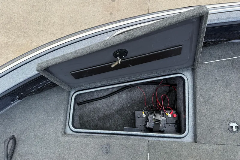 Slide: The Image of Open storage compartment in 2015 Lund 202 Pro-V GL boat, showing battery and wiring. - 13