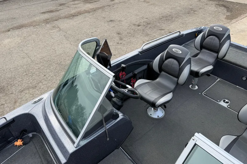 Slide: The Image of 2015 Lund 202 Pro-V GL boat interior with two gray seats and steering console. - 15