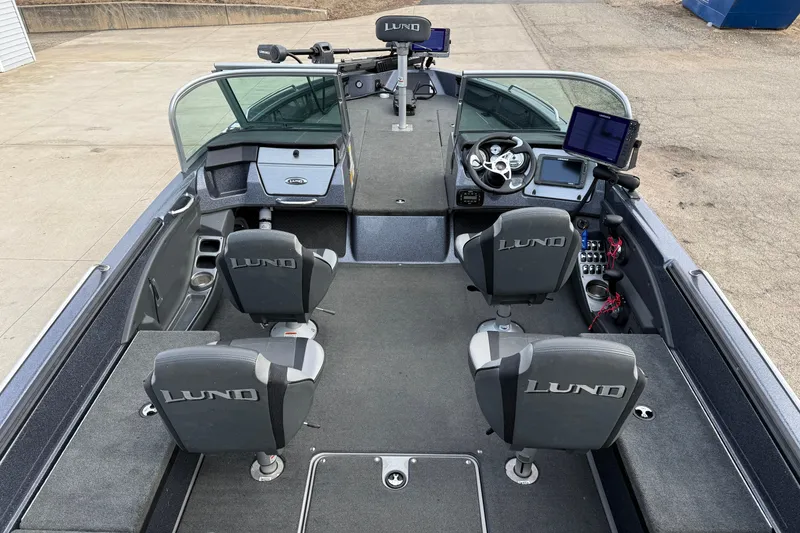 Slide: The Image of 2015 Lund 202 Pro-V GL boat interior with four seats and modern navigation equipment. - 17