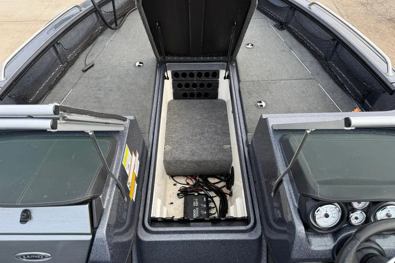Slide: The Image of 2015 Lund 202 Pro-V GL boat interior with open storage compartment and dashboard view. - 18