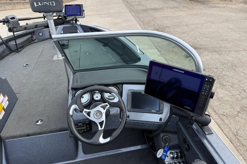 Slide: The Image of 2015 Lund 202 Pro-V GL boat dashboard with Lowrance electronics and steering wheel. - 22