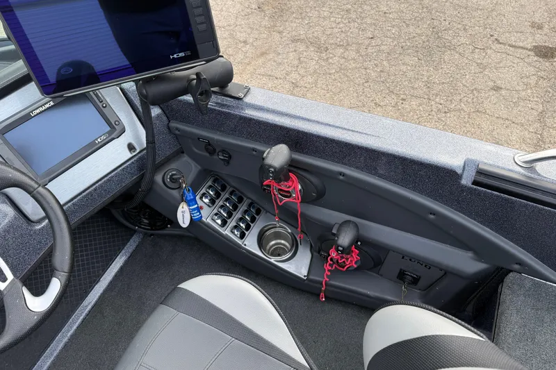 Slide: The Image of 2015 Lund 202 Pro-V GL boat cockpit with steering wheel, control panel, and navigation screens. - 23
