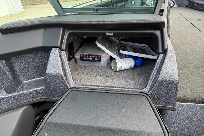 Slide: The Image of Storage compartment in a 2015 Lund 202 Pro-V GL boat with various items inside. - 26