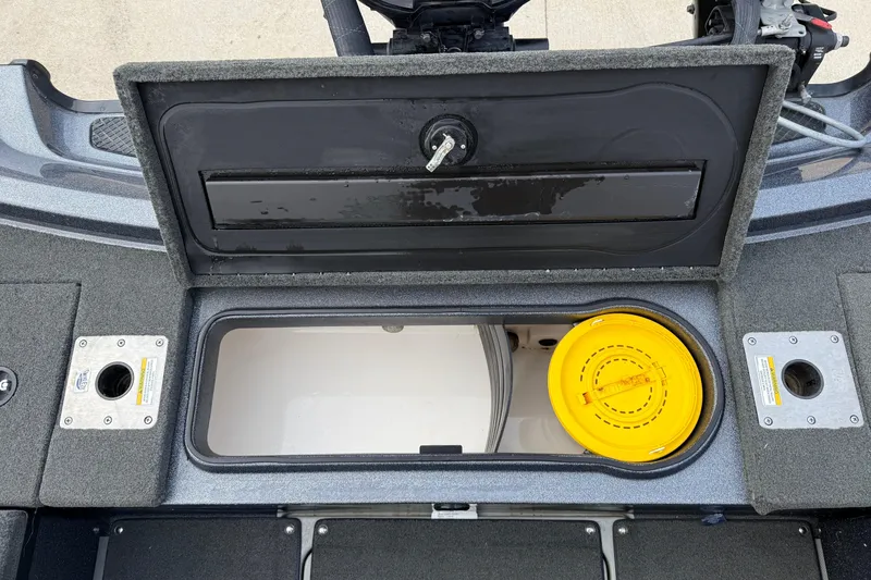 Slide: The Image of 2015 Lund 202 Pro-V GL boat storage compartment with yellow container and open hatch. - 30