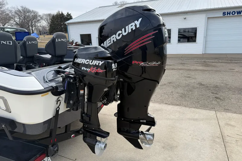 Slide: The Image of 2015 Lund 202 Pro-V GL boat with dual Mercury outboard motors in a showroom setting. - 8