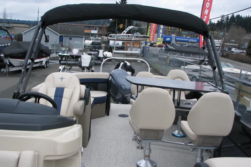 Slide: The Image of 2026 Berkshire 24 E CTS pontoon boat with seating and table, displayed at a dealership. - 8