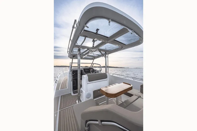 Slide: The Image of 2025 Nimbus T9 boat interior with sleek design, glass roof, and wooden table on open water. - 7
