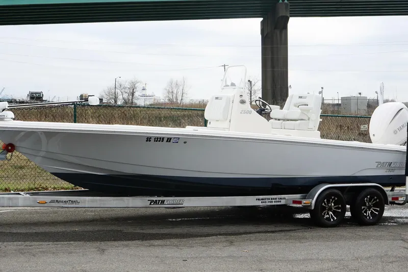 Slide: The Image of 2023 Pathfinder 2500 Hybrid boat on trailer, parked outdoors under a bridge. - 11