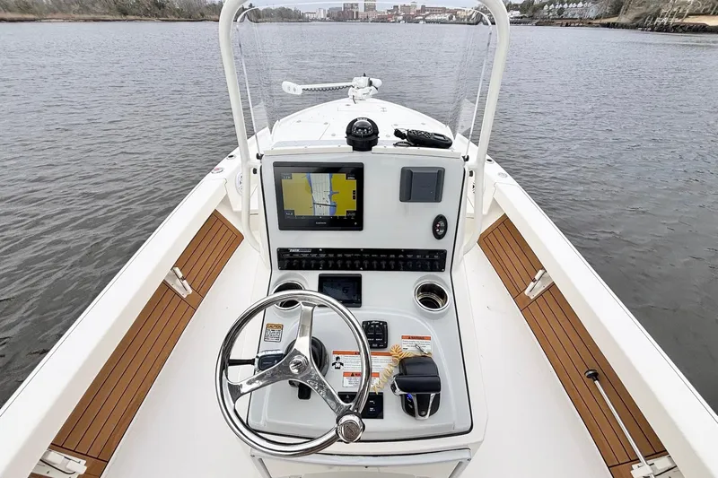 Slide: The Image of 2023 Pathfinder 2500 Hybrid boat console with navigation screen on calm water. - 12