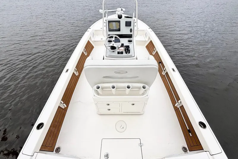 Slide: The Image of 2023 Pathfinder 2500 Hybrid boat interior with helm, wood accents, and water view. - 14