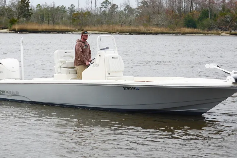 Slide: The Image of 2023 Pathfinder 2500 Hybrid boat on water with person standing at helm. - 5