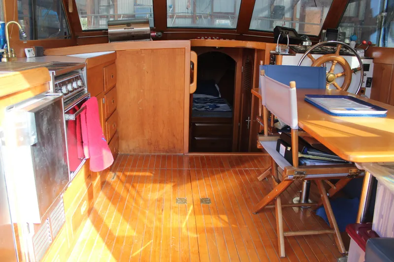 Slide: The Image of 1985 Ventura South Bay Flybridge Sedan Sport interior with wooden flooring and nautical decor. - 14