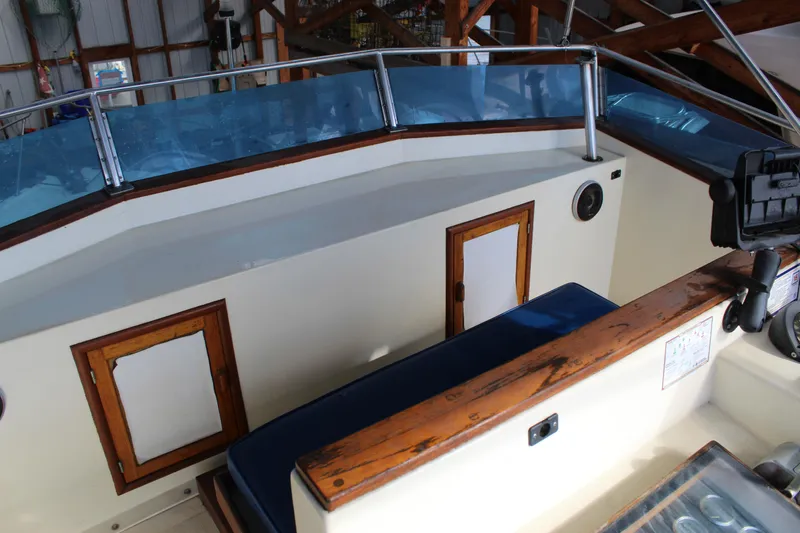 Slide: The Image of 1985 Ventura South Bay Flybridge Sedan Sport interior with blue seating and wooden accents. - 16