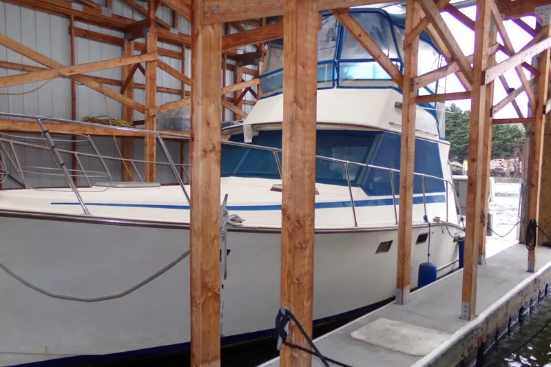 Slide: The Image of 1985 Ventura South Bay Flybridge Sedan Sport docked in a wooden boathouse. - 2