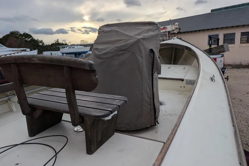 Slide: The Image of 1998 Belkov skiff with wooden bench, covered console, and overcast sky in the background. - 10