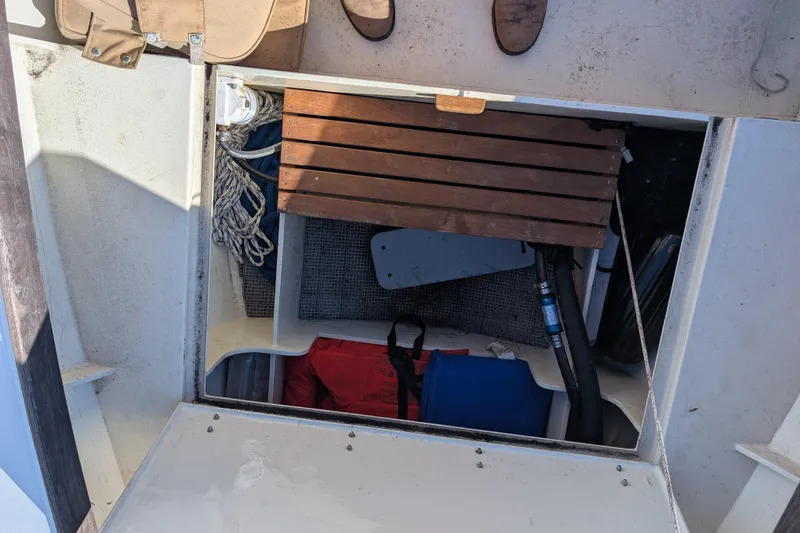Slide: The Image of 1998 Belkov skiff storage compartment with ropes, wooden slats, and boating equipment. - 16