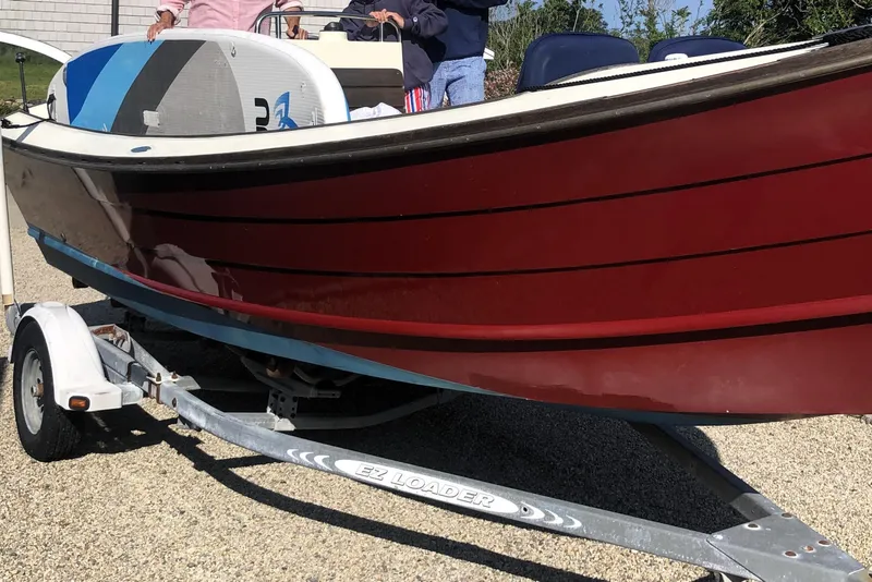 Slide: The Image of 1998 Belkov skiff on trailer, red hull, paddleboard on deck. - 25