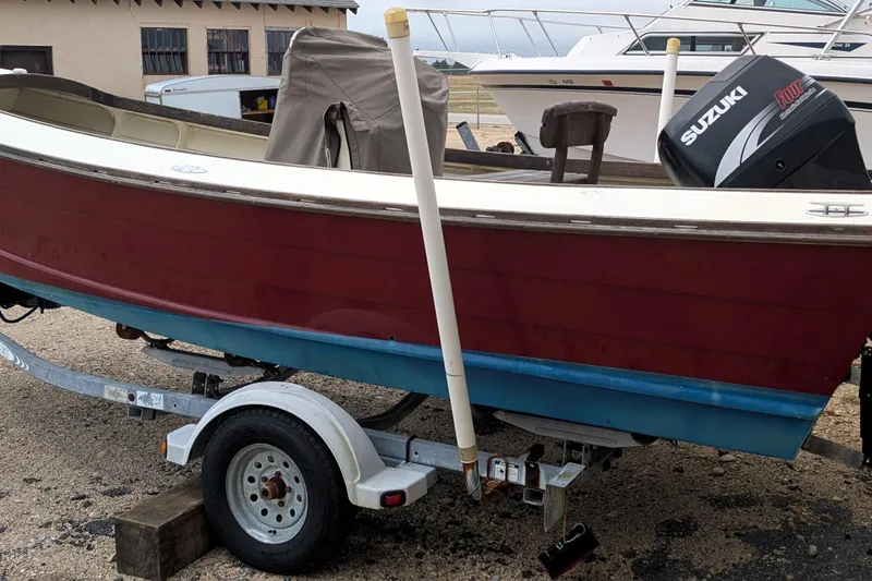 Slide: The Image of 1998 Belkov skiff with Suzuki motor on trailer, parked outdoors. - 27