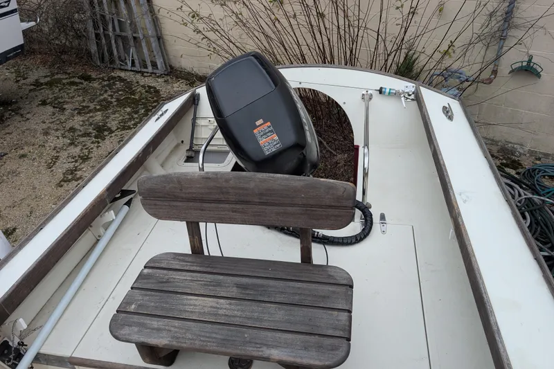 Slide: The Image of 1998 Belkov skiff with wooden bench and outboard motor, parked outdoors. - 28