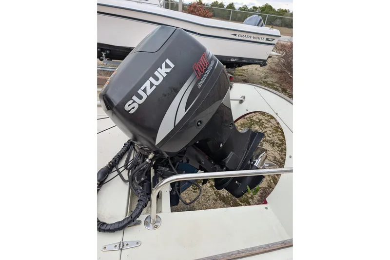 Slide: The Image of 1998 Belkov skiff with Suzuki outboard motor, parked near another boat. - 34