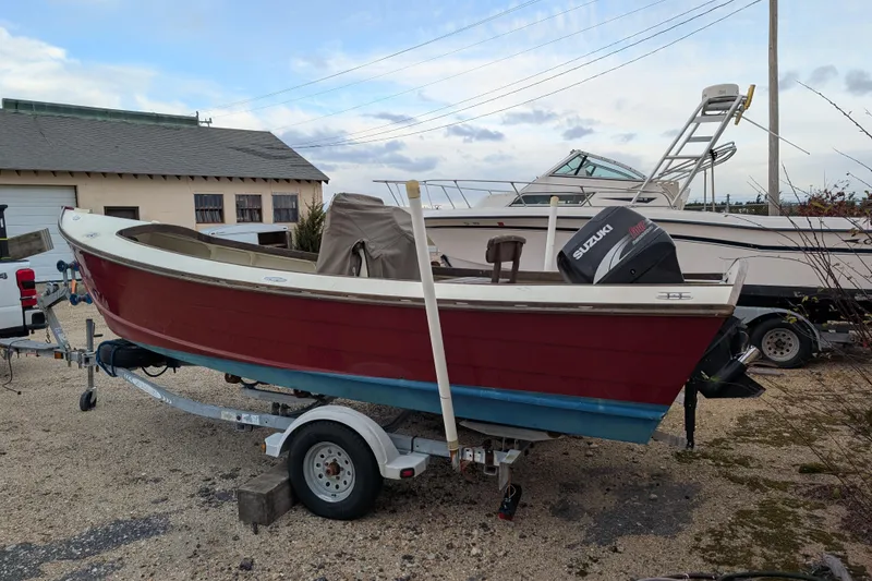 Slide: The Image of 1998 Belkov skiff boat on trailer with Suzuki outboard motor, parked outdoors. - 36