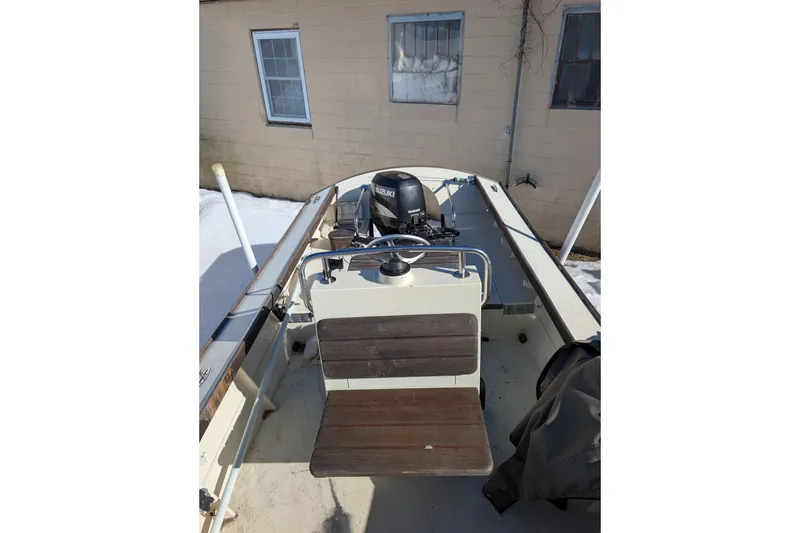 Slide: The Image of 1998 Belkov skiff with Suzuki outboard motor, parked near a building in snowy conditions. - 7