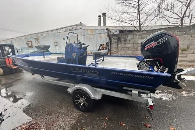 Slide: The Image of 2024 Lund 2070 Predator CC boat on trailer, blue exterior, parked outdoors. - 3